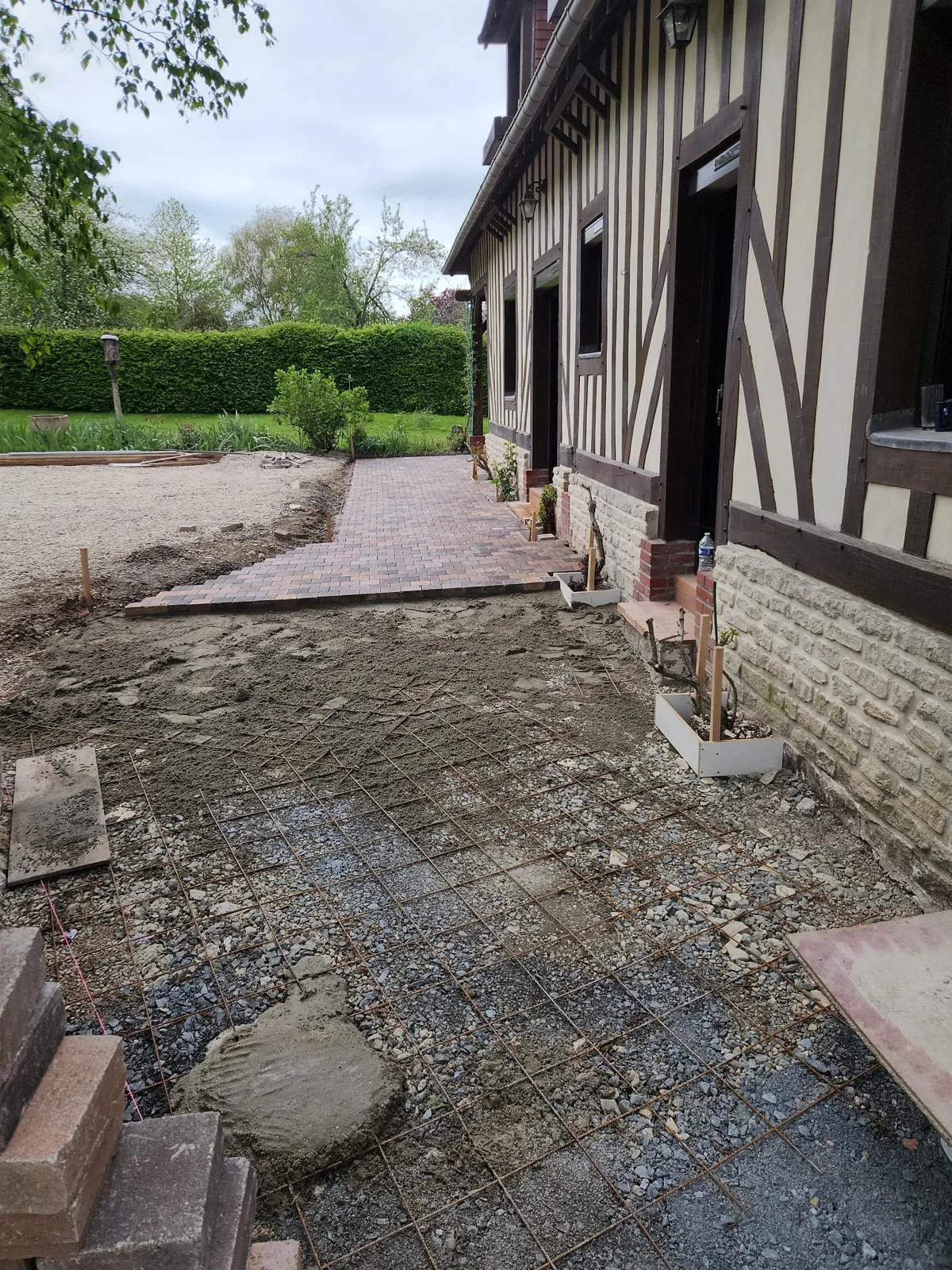 Cheminement pavé longeant la façade d’une maison à colombages
