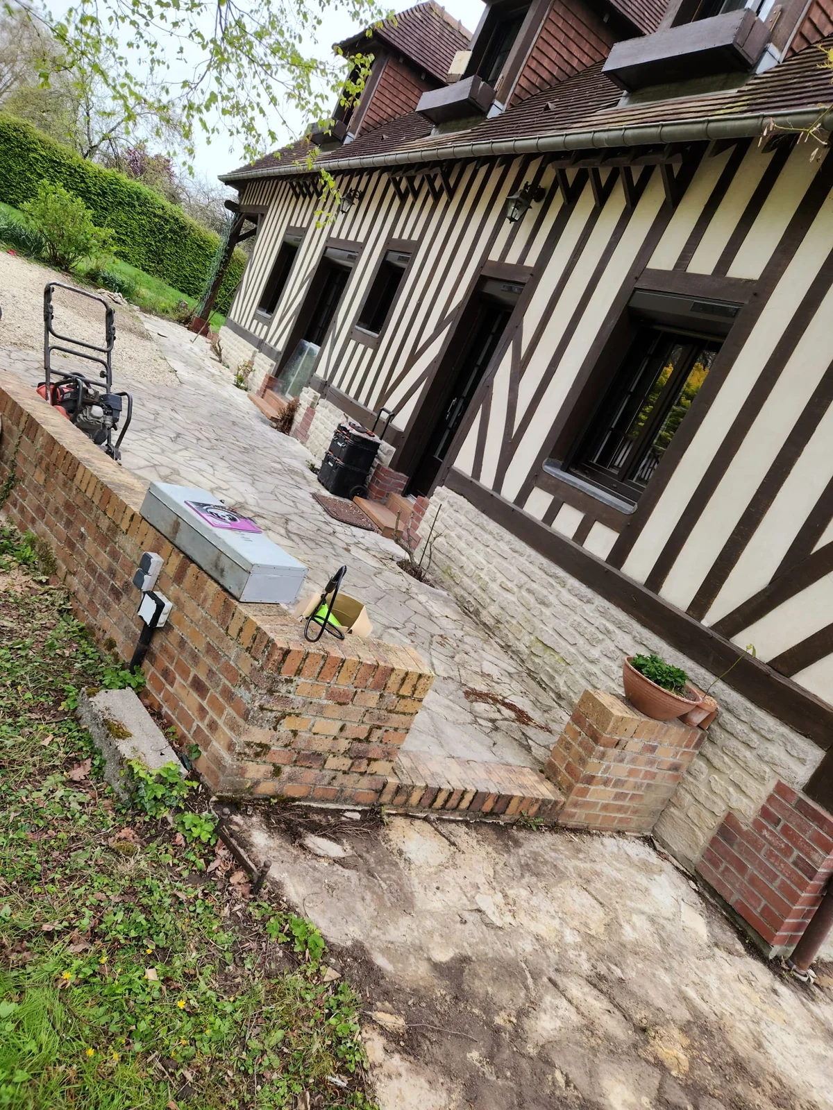 Cheminement pavé en cours de réalisation entre façade et terrain