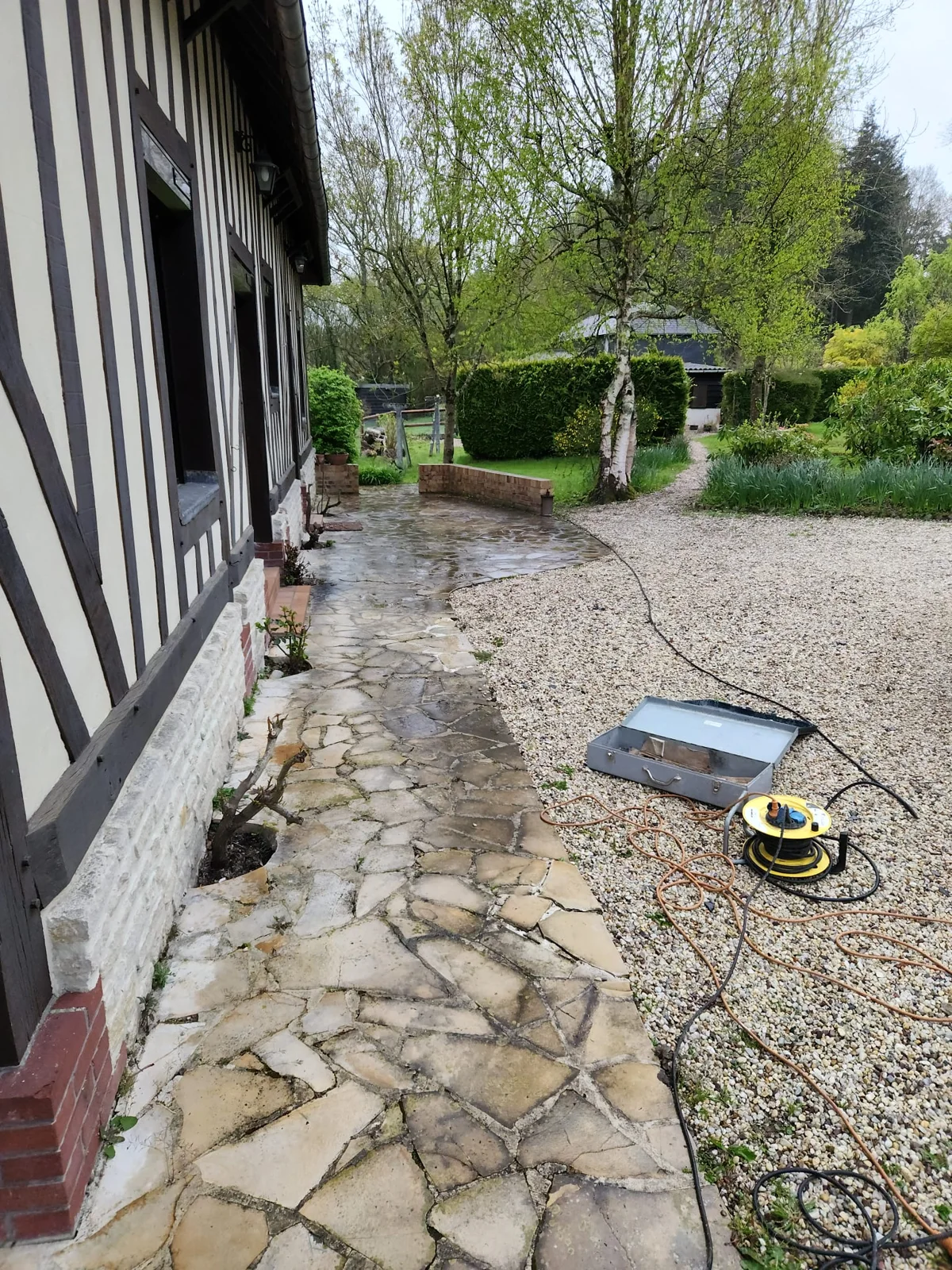 Jonction entre pavés et gravier au pied d’une façade